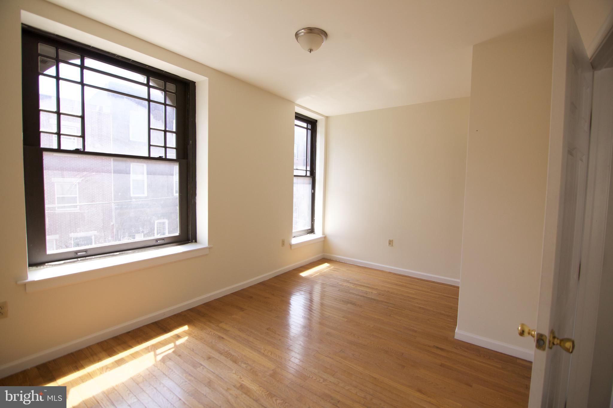 1522 North 17th Street, Unit 2 Philadelphia, PA 19121 - Photo 3 of 10 a view of an empty room with wooden floor and a window