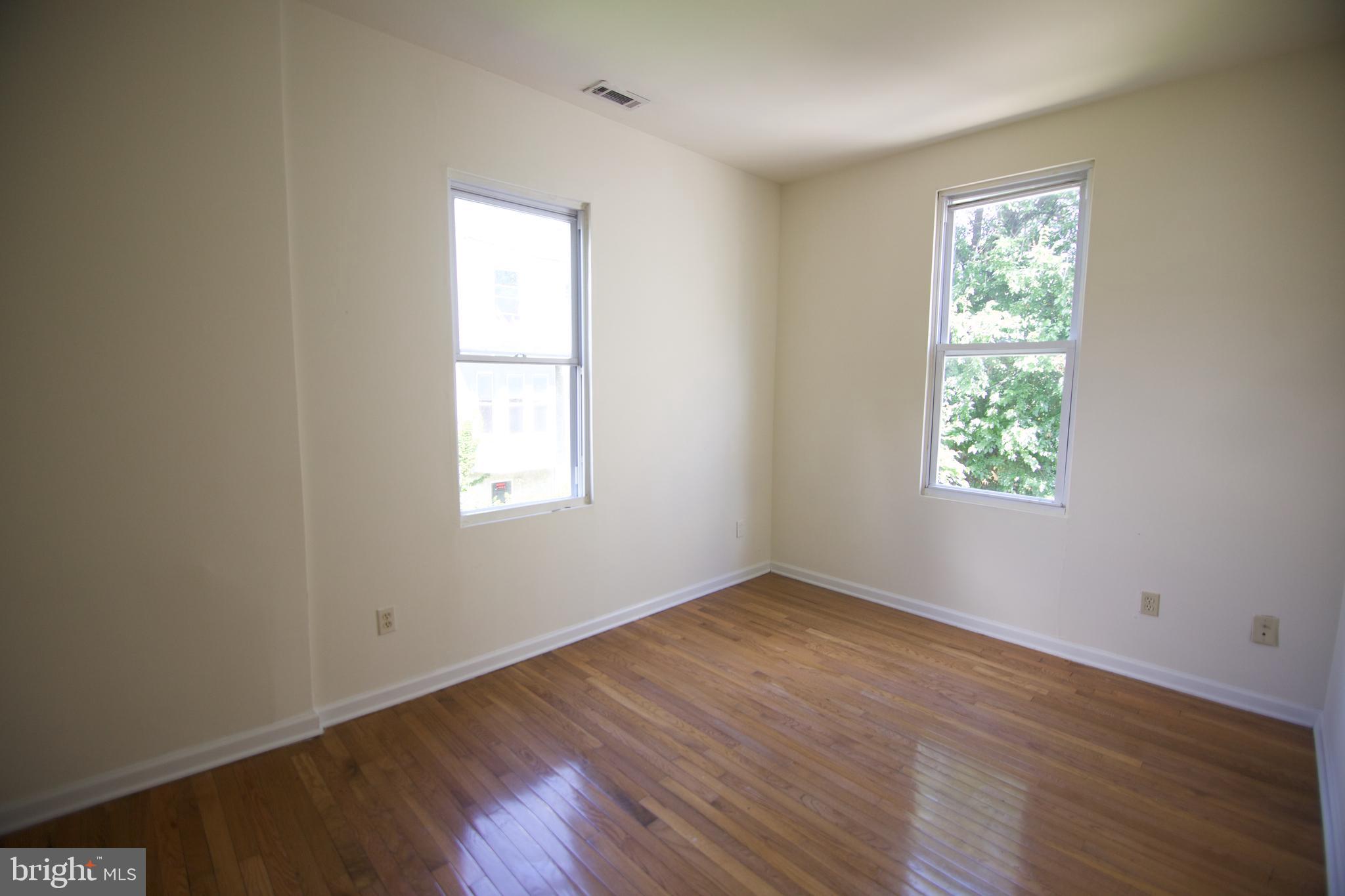 1522 North 17th Street, Unit 2 Philadelphia, PA 19121 - Photo 9 of 10 an empty room with wooden floor and windows