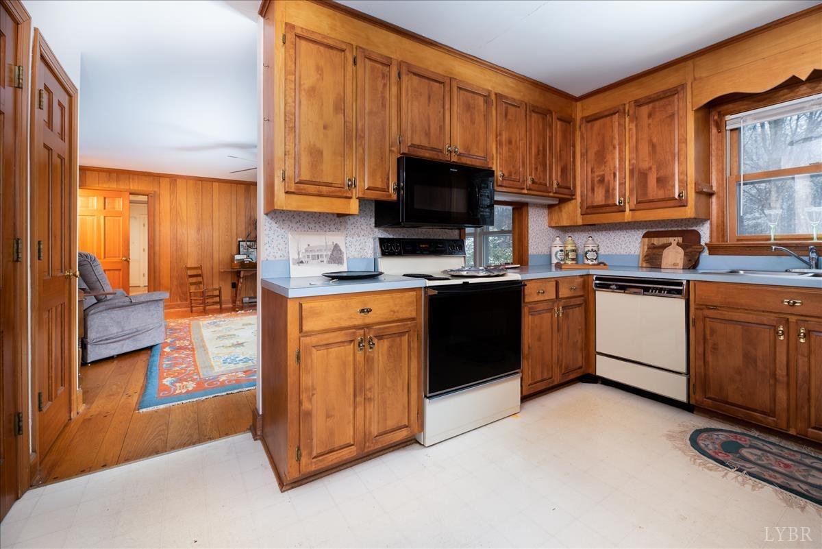 1086 Redfields Road Appomattox, VA 24522 - Photo 19 of 33 a kitchen with stainless steel appliances granite countertop a stove a sink dishwasher and a microwave oven with cabinets