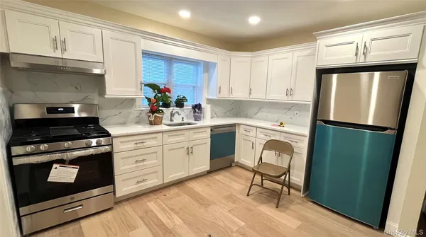 a kitchen with white cabinets and white appliances