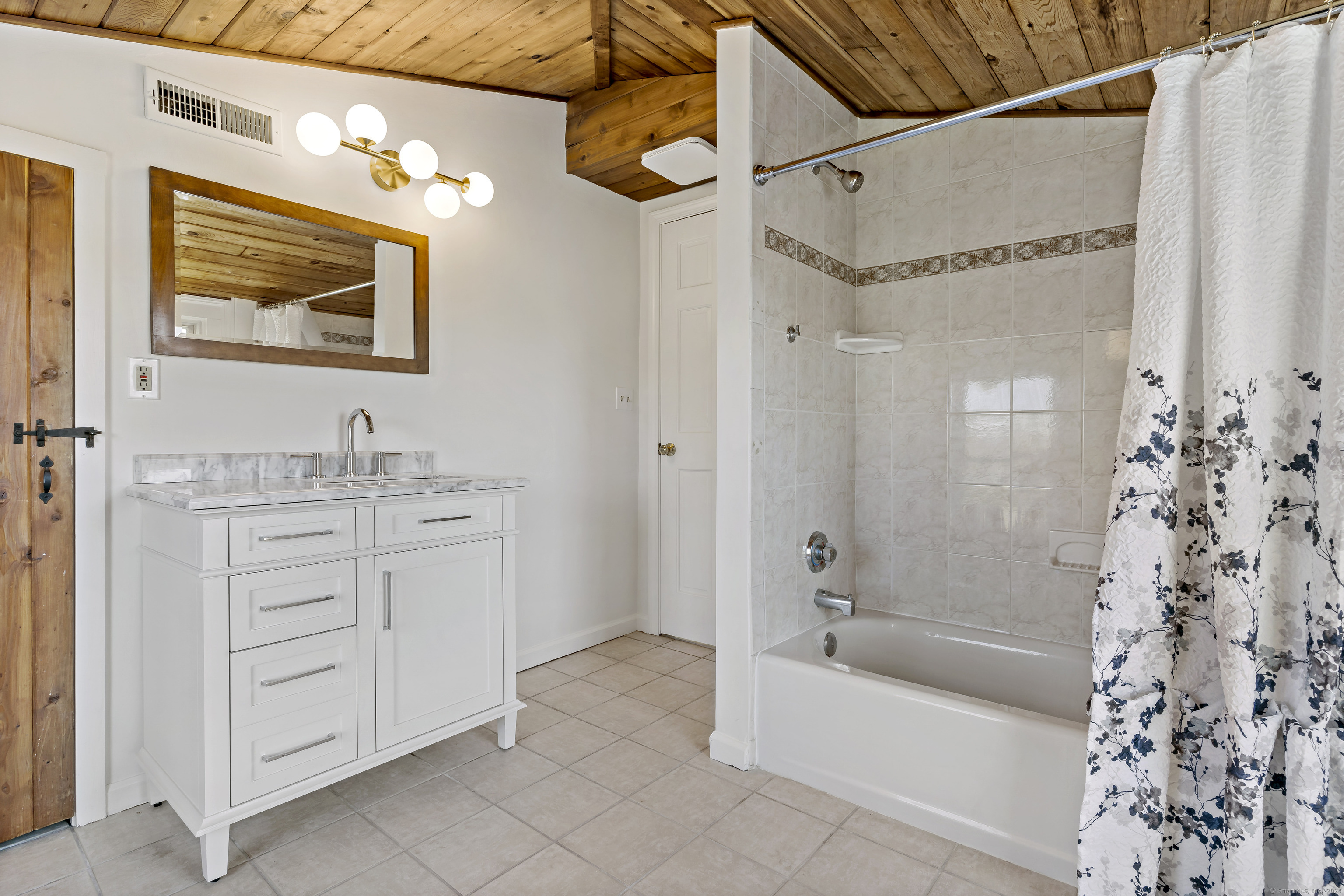 14 2nd Avenue Branford, CT 06405 - Photo 22 of 29 a bathroom with a granite countertop sink a mirror a bathtub and shower