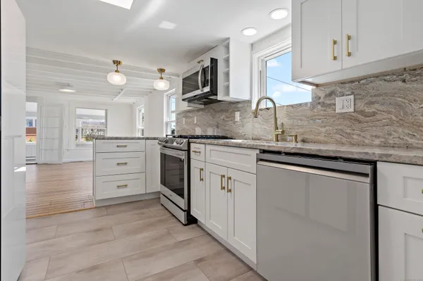 a kitchen with stainless steel appliances granite countertop a sink and cabinets