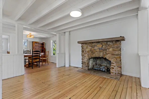 an empty room with wooden floor fireplace and furniture