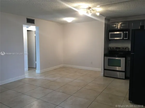 a view of a kitchen with a stove cabinets and a kitchen space