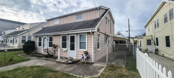 a view of a house with backyard wooden fence and porch