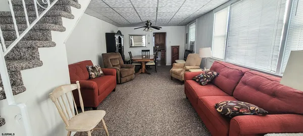 a kitchen with stainless steel appliances granite countertop a refrigerator a stove a sink and white cabinets with wooden floor