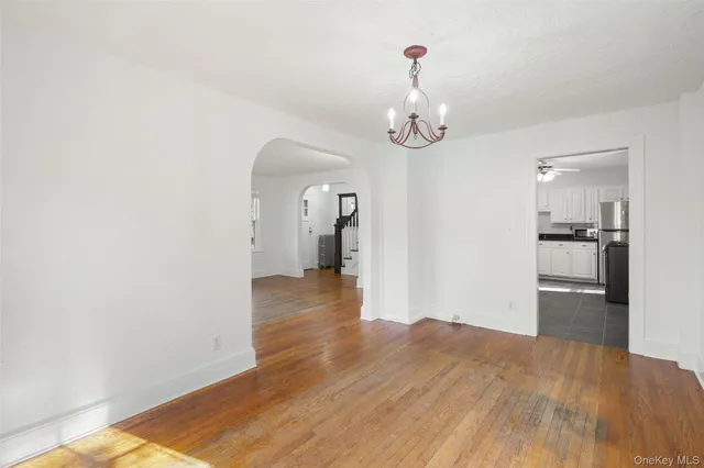 a view of a room with wooden floor and kitchen view