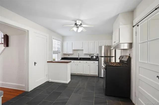 a kitchen with a refrigerator and white cabinets