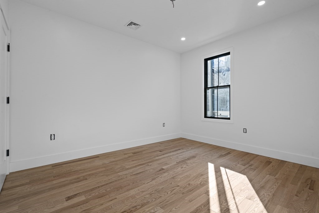 3 Pulaski Avenue Boston, MA 02127 - Photo 11 of 19 wooden floor in an empty room with a window