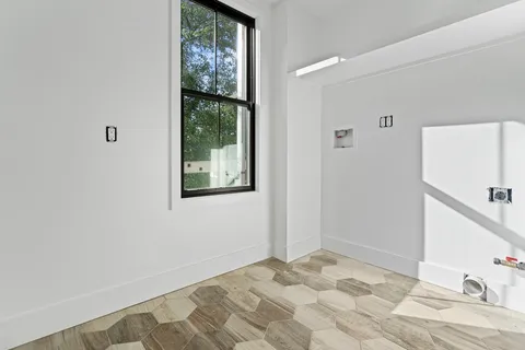 a view of a bedroom with wooden floor and a window