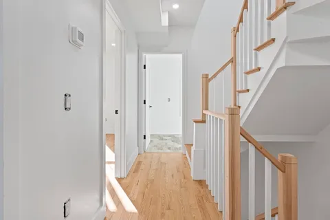 a view of a hallway with wooden floor and staircase