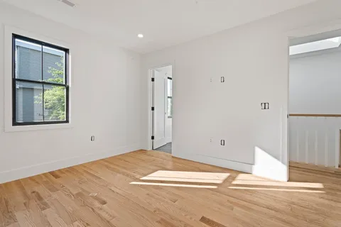 a view of a room with wooden floor and window