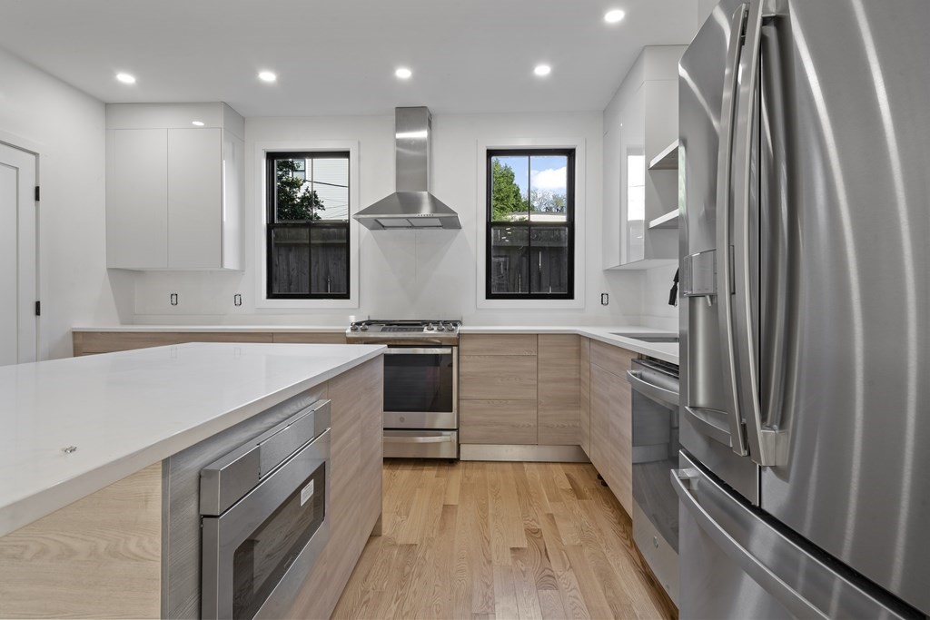 3 Pulaski Avenue Boston, MA 02127 - Photo 2 of 19 a kitchen with white cabinets and stainless steel appliances