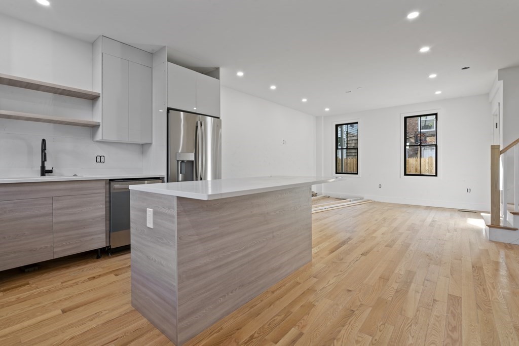 3 Pulaski Avenue Boston, MA 02127 - Photo 4 of 19 a kitchen with stainless steel appliances kitchen island wooden floors wooden cabinets and entryway