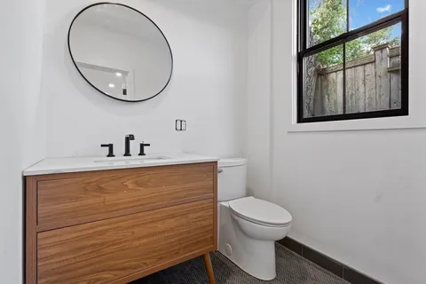 a bathroom with a toilet a sink and mirror