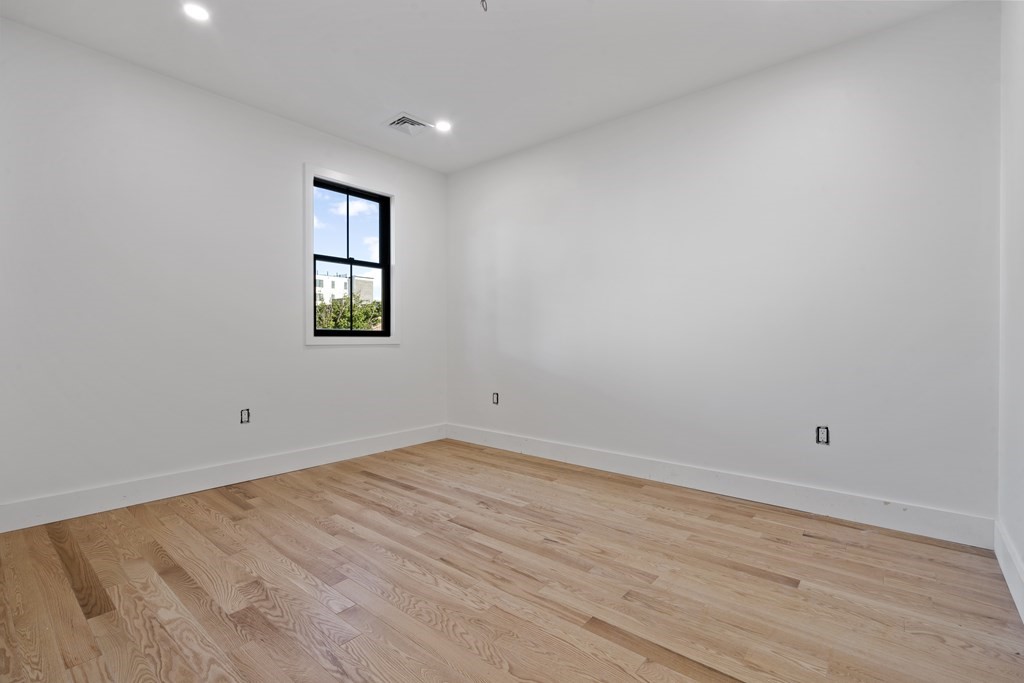 3 Pulaski Avenue Boston, MA 02127 - Photo 8 of 19 an empty room with wooden floor and windows