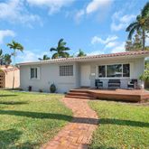 a front view of a house with a garden and patio