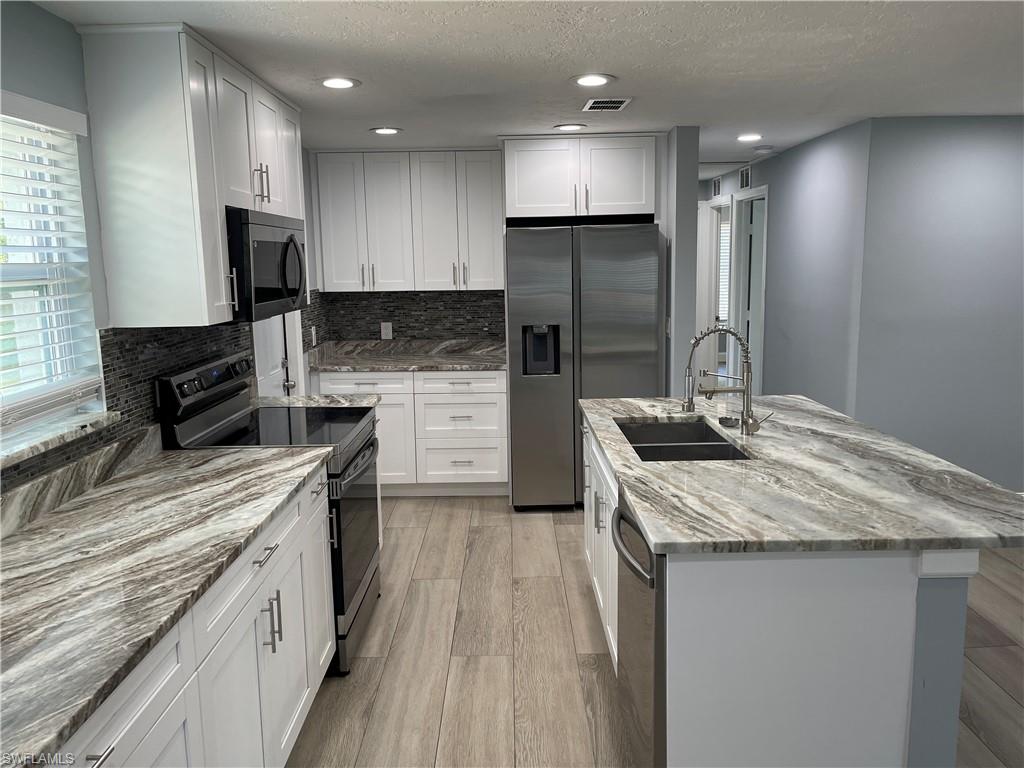 528 14th Street North Naples, FL 34102 - Photo 12 of 19 a kitchen with a sink stove and refrigerator