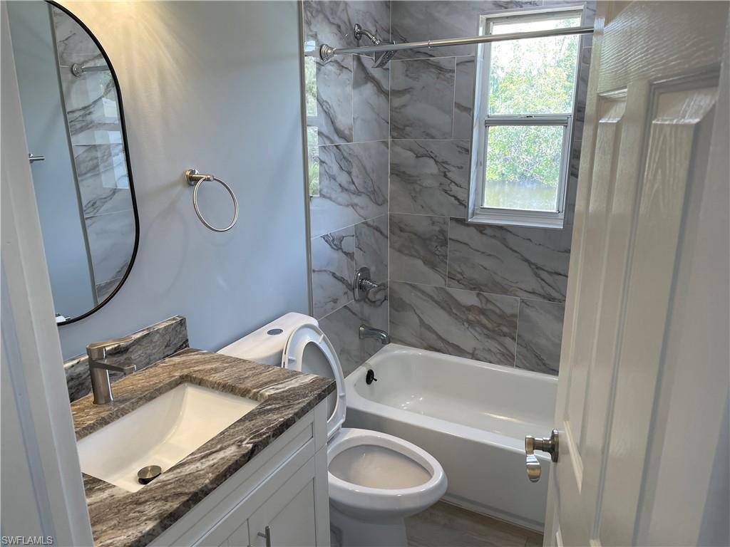 528 14th Street North Naples, FL 34102 - Photo 18 of 19 a bathroom with a granite countertop sink toilet and shower