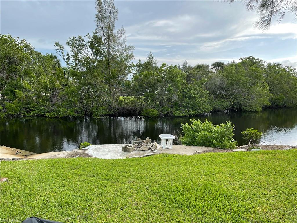 528 14th Street North Naples, FL 34102 - Photo 4 of 19 a view of a lake with a bench and trees in the background