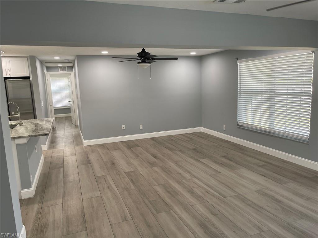 528 14th Street North Naples, FL 34102 - Photo 7 of 19 an empty room with wooden floor and windows