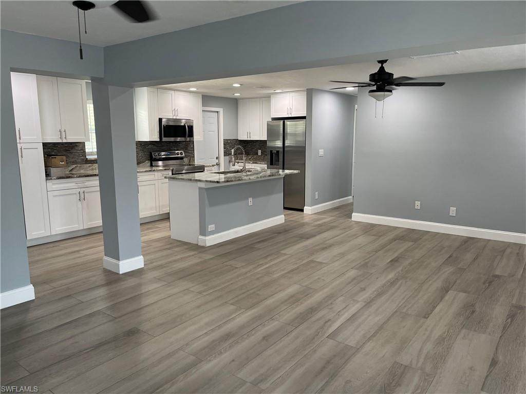 528 14th Street North Naples, FL 34102 - Photo 8 of 19 a large kitchen with cabinets wooden floor and stainless steel appliances