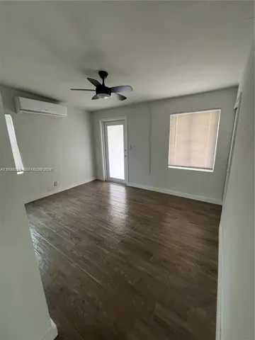 an empty room with windows and a ceiling fan