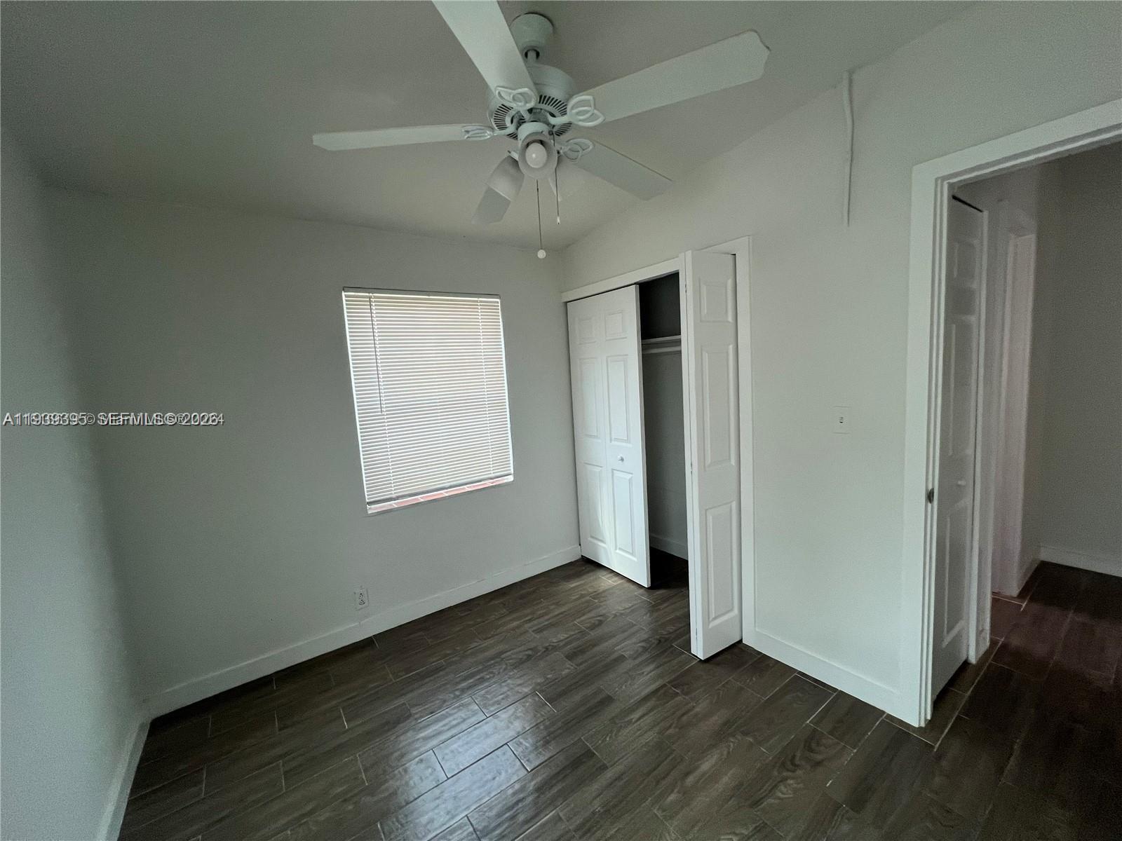 2240 Rutland Street Opa-Locka, FL 33054 - Photo 17 of 19 an empty room with wooden floor chandelier fan and windows