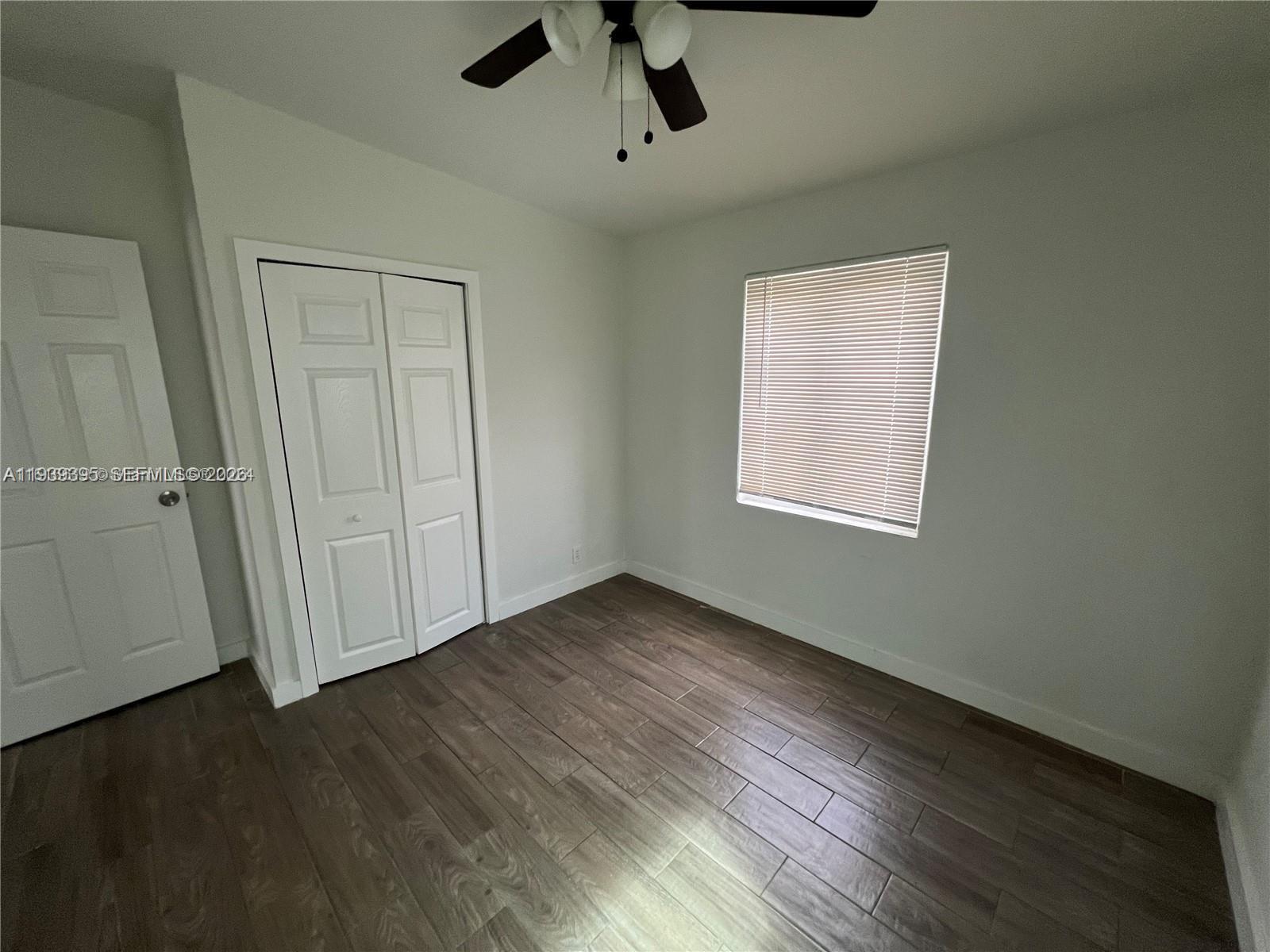 2240 Rutland Street Opa-Locka, FL 33054 - Photo 18 of 19 an empty room with wooden floor cabinet and windows
