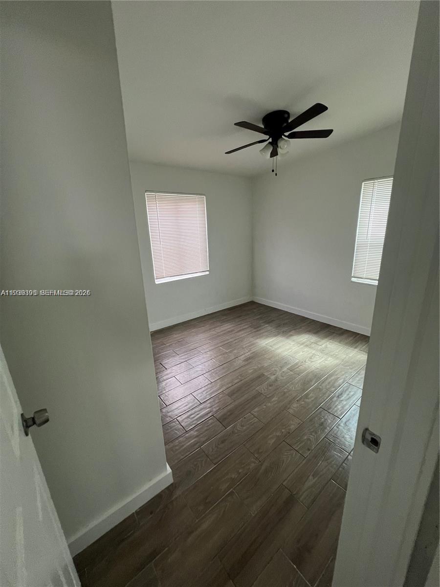 2240 Rutland Street Opa-Locka, FL 33054 - Photo 19 of 19 an empty room with wooden floor a ceiling fan and windows