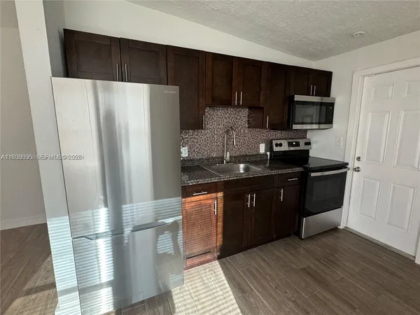 a kitchen with stainless steel appliances a refrigerator and a stove top oven