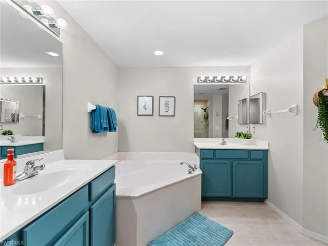 a bathroom with a granite countertop sink mirror and bathtub