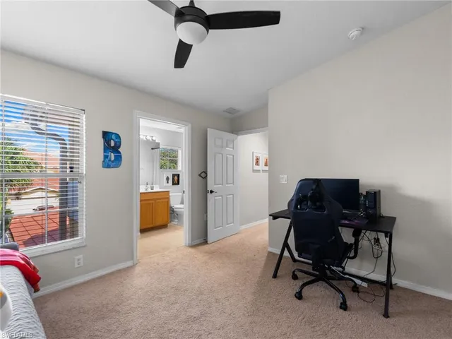 a view of a workspace with furniture and a window