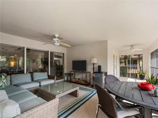 a living room with furniture a flat screen tv and large window