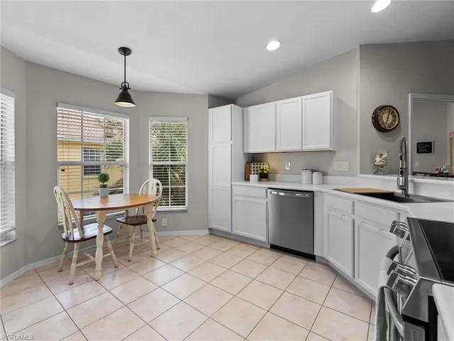 a kitchen a sink a window and chairs