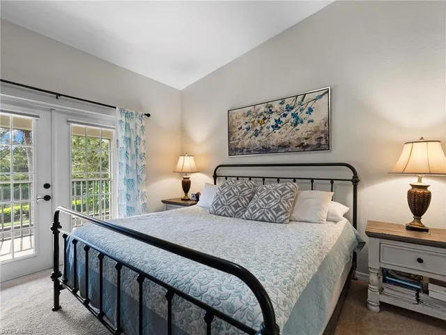 a bedroom with a large bed and a lamp on table