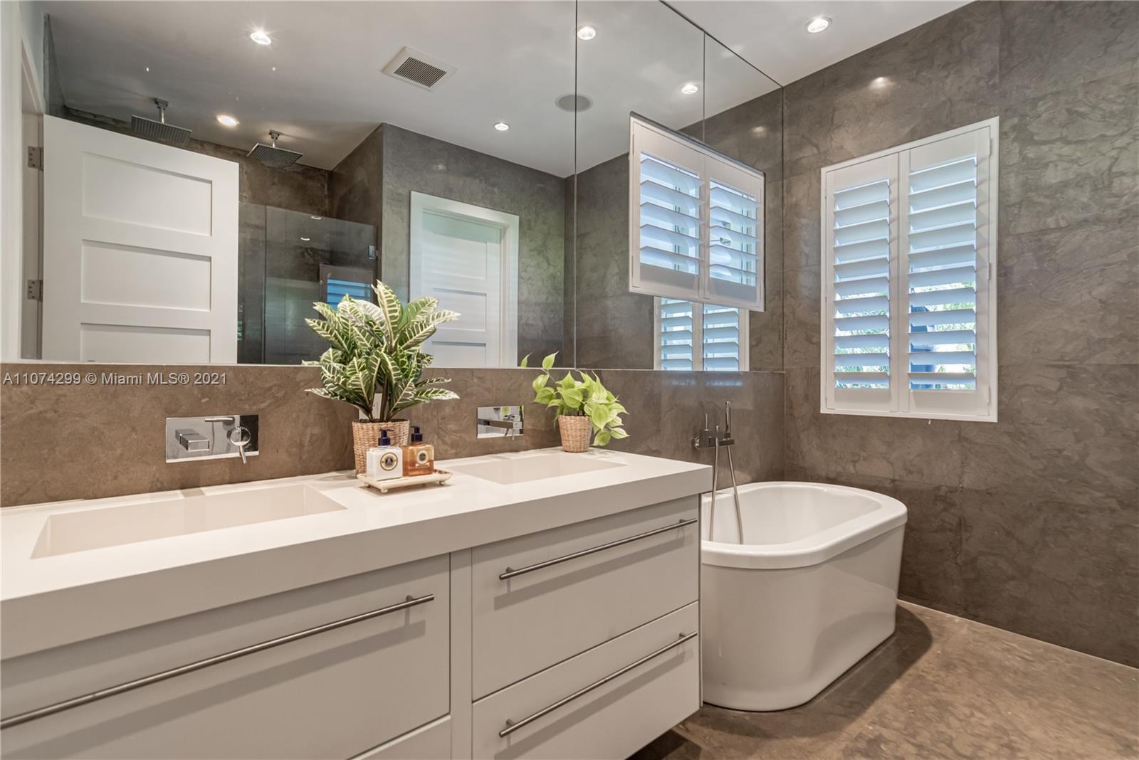 325 Hampton Lane Key Biscayne, FL 33149 - Photo 15 of 37 a bathroom with a granite countertop sink a toilet a mirror and bathtub