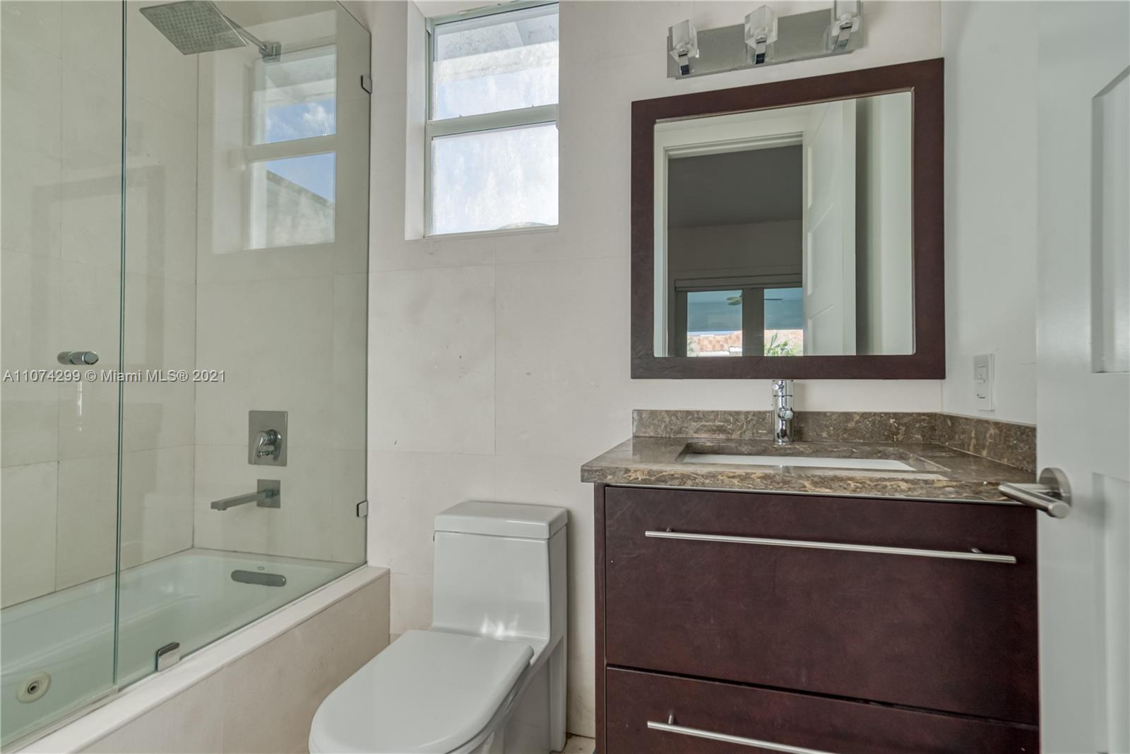 325 Hampton Lane Key Biscayne, FL 33149 - Photo 19 of 37 a bathroom with a granite countertop sink toilet and shower