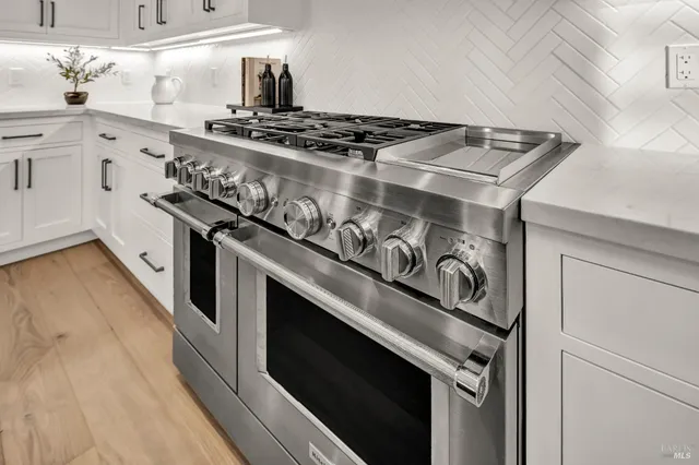 a kitchen with a sink a counter top space stainless steel appliances and cabinets