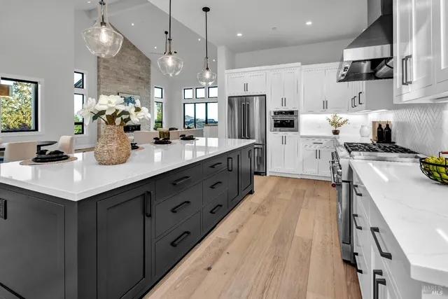 a kitchen with white cabinets and stainless steel appliances