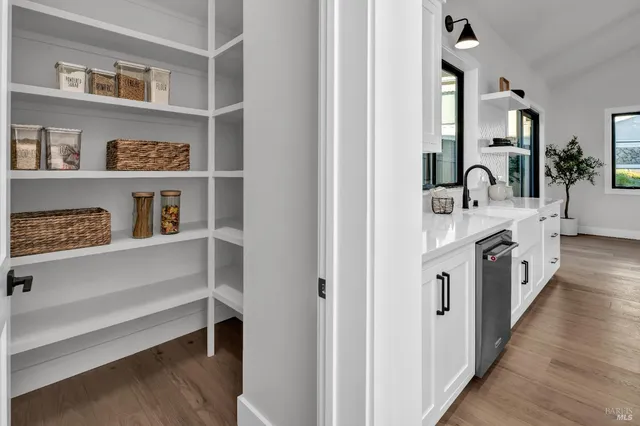 a kitchen with stainless steel appliances kitchen island granite countertop a table chairs and a wooden floor