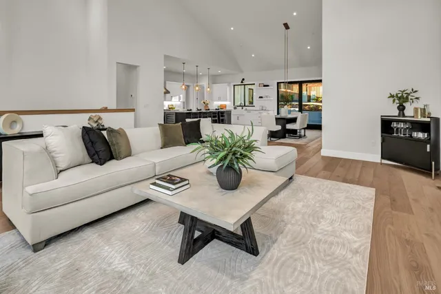 a kitchen with stainless steel appliances kitchen island wooden floors stove and white cabinets