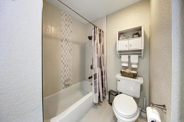 a white toilet sitting next to a bath tub shower