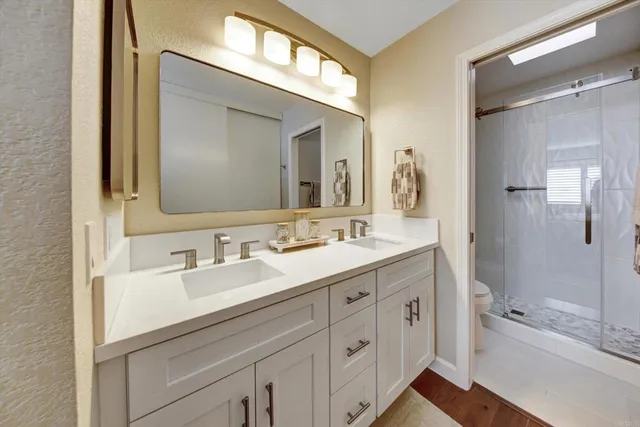 a bathroom with a bathtub a double vanity sink and mirror