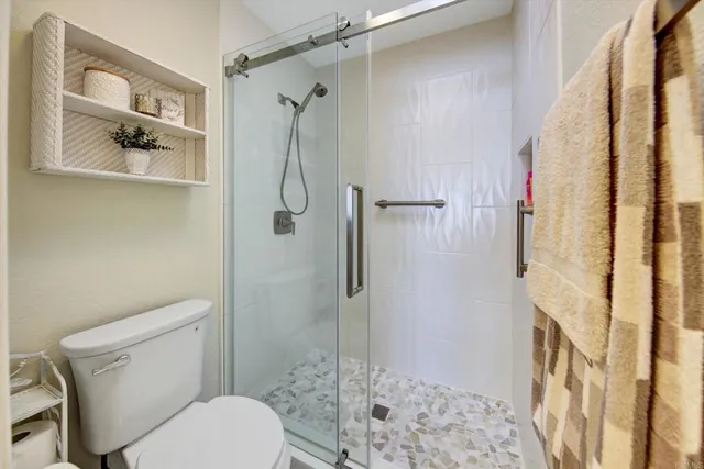 a bathroom with a toilet and a shower
