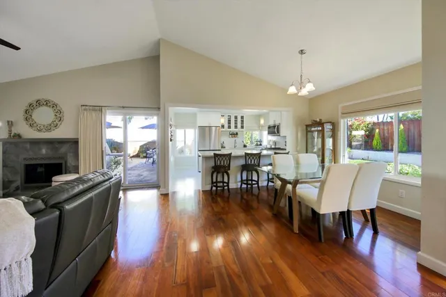 a dining room with furniture a fireplace and wooden floor