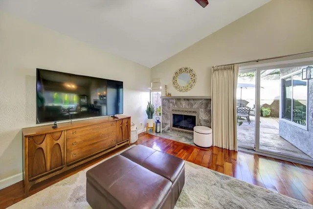 a living room with furniture a flat screen tv and a fireplace