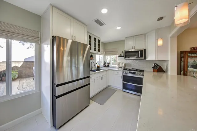 a kitchen with stainless steel appliances a refrigerator stove microwave and sink