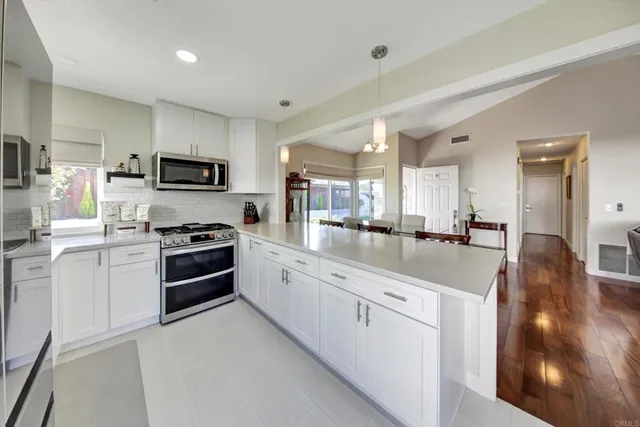 a large white kitchen with stainless steel appliances and a sink