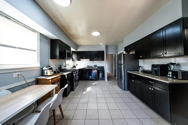 a large kitchen with stainless steel appliances lots of counter space and a sink